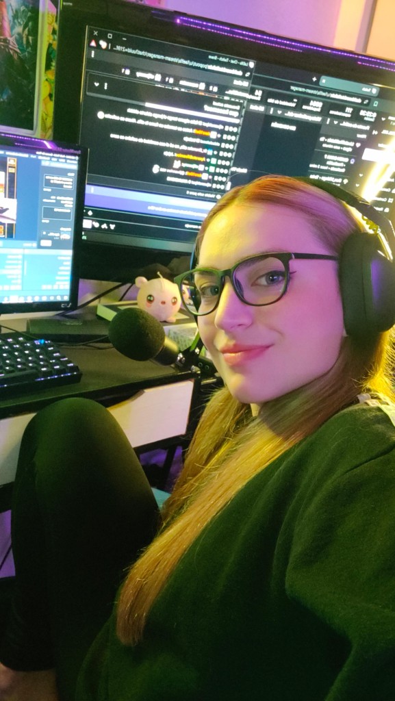 La Elfa con auriculares, sentada frente a sus monitores durante un directo.