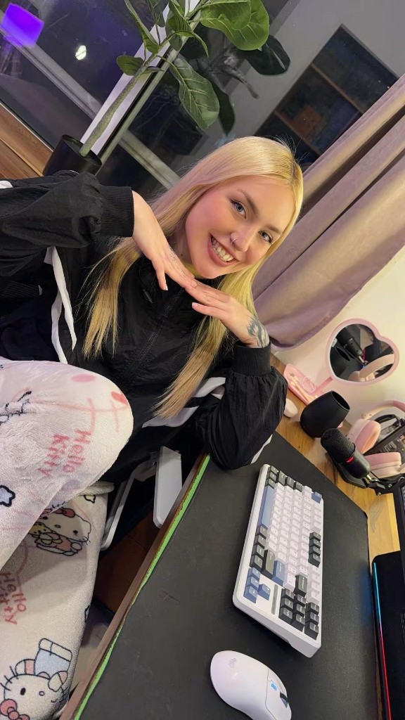 La Elfa sonriendo en su escritorio, con el teclado y el micrófono del stream.